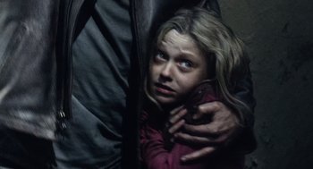 Movie still from “War of the Worlds” (2005), directed by Steven Spielberg – A woman holding a man's arm while he holds a cell phone in her hand; Close Up shot, Over the shoulder angle