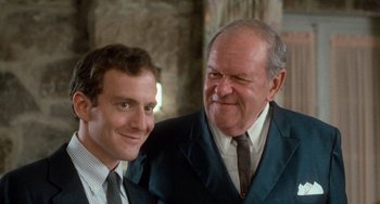 Movie still from “Dirty Dancing” (1987), directed by Emile Ardolino – Two men in suits posing for a picture together; Close Up shot, Over the shoulder angle
