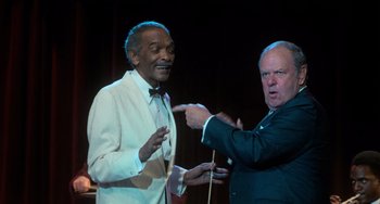 Movie still from “Dirty Dancing” (1987), directed by Emile Ardolino – Two men in suits and bow ties one of which is pointing; Medium shot, Over the shoulder angle