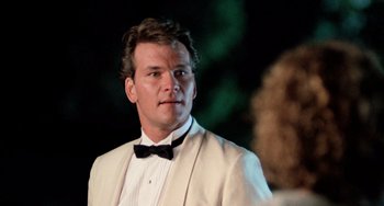 Movie still from “Dirty Dancing” (1987), directed by Emile Ardolino – A man wearing a tuxedo and a bow tie; Close Up shot, Low angle