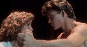 Movie still from “Dirty Dancing” (1987), directed by Emile Ardolino – A man and a woman are looking at one another; Close Up shot, Low angle
