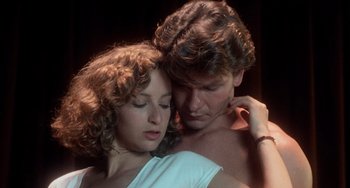 Movie still from “Dirty Dancing” (1987), directed by Emile Ardolino – A man and a woman embracing each other in the dark; Close Up shot, Low angle