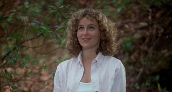 Movie still from “Dirty Dancing” (1987), directed by Emile Ardolino – A woman with curly hair wearing a white and pink shirt; Close Up shot, Low angle