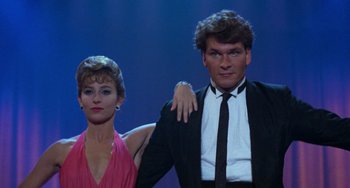 Movie still from “Dirty Dancing” (1987), directed by Emile Ardolino – A man and a woman posing for a picture; Medium shot, Low angle