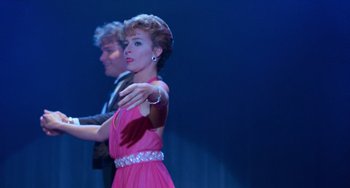 Movie still from “Dirty Dancing” (1987), directed by Emile Ardolino – A woman in a pink dress and a man in a black suit; Medium shot, Low angle