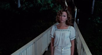 Movie still from “Dirty Dancing” (1987), directed by Emile Ardolino – A woman standing on a bridge at night; Medium shot, Over the shoulder angle