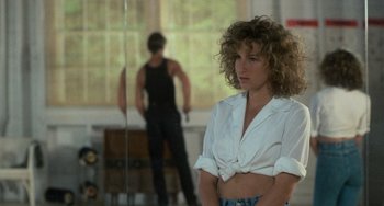 Movie still from “Dirty Dancing” (1987), directed by Emile Ardolino – A woman in a white shirt and a man in a black shirt; Medium shot, Over the shoulder angle