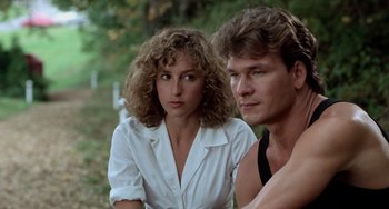 Movie still from “Dirty Dancing” (1987), directed by Emile Ardolino – A man and a woman sitting next to each other in a forest; Close Up shot, Over the shoulder angle