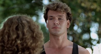 Movie still from “Dirty Dancing” (1987), directed by Emile Ardolino – A young man with curly hair talking to a young woman; Close Up shot, Low angle
