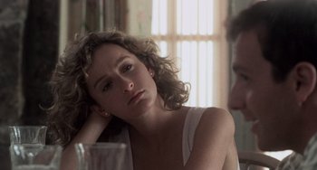 Movie still from “Dirty Dancing” (1987), directed by Emile Ardolino – A woman sitting in front of a man in front of a window; Close Up shot, Over the shoulder angle