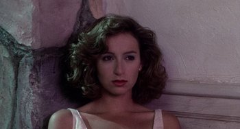 Movie still from “Dirty Dancing” (1987), directed by Emile Ardolino – A beautiful woman with curly brown hair wearing a white top; Close Up shot, Low angle