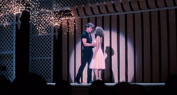 Movie still from “Dirty Dancing” (1987), directed by Emile Ardolino – A man and a woman on a stage in front of a crowd of onlookers; Wide shot, Low angle