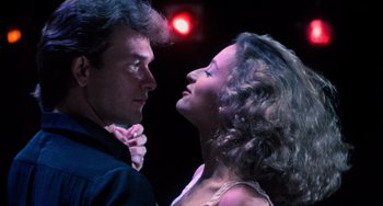 Movie still from “Dirty Dancing” (1987), directed by Emile Ardolino – A man and a woman dancing in front of a red light; Close Up shot, Low angle