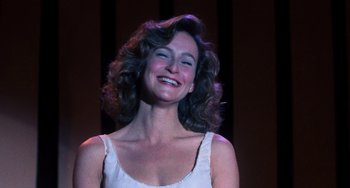 Movie still from “Dirty Dancing” (1987), directed by Emile Ardolino – A woman smiling with her mouth open; Close Up shot, Low angle