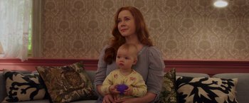Movie still from “Disenchanted” (2022), directed by Adam Shankman – A woman holding a baby in her arms; Close Up shot, Over the shoulder angle