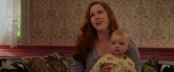 Movie still from “Disenchanted” (2022), directed by Adam Shankman – A woman holding a baby in her arms; Close Up shot, Over the shoulder angle