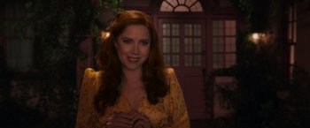 Movie still from “Disenchanted” (2022), directed by Adam Shankman – A woman in a yellow dress smiling for the camera; Medium shot, Over the shoulder angle
