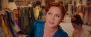 A person with red hair wearing a blue dress