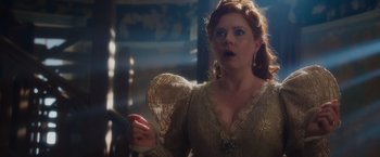 Movie still from “Disenchanted” (2022), directed by Adam Shankman – A woman with red hair and blue eyes wearing a gold dress; Close Up shot, Over the shoulder angle