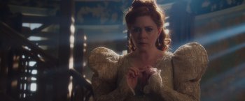 Movie still from “Disenchanted” (2022), directed by Adam Shankman – A woman with red hair wearing a gold dress; Close Up shot, Over the shoulder angle