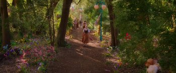 Movie still from “Disenchanted” (2022), directed by Adam Shankman – A group of people walking down a dirt path; Wide shot, High angle