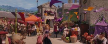 Movie still from “Disenchanted” (2022), directed by Adam Shankman – A group of people standing around a market area; Wide shot, High angle