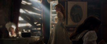 Movie still from “Disenchanted” (2022), directed by Adam Shankman – A woman in a white dress standing next to a window; Medium shot, Over the shoulder angle