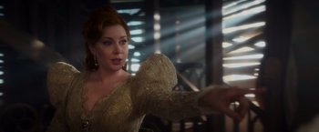 Movie still from “Disenchanted” (2022), directed by Adam Shankman – A woman in a white dress is holding her arm out; Medium shot, Over the shoulder angle