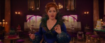 Movie still from “Disenchanted” (2022), directed by Adam Shankman – A woman in a blue dress with a peacock feather around her neck; Medium shot, Over the shoulder angle