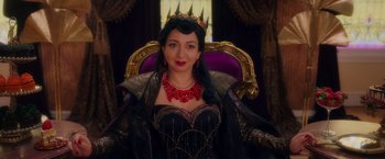 Movie still from “Disenchanted” (2022), directed by Adam Shankman – A woman wearing a black dress and a red necklace; Medium shot, Over the shoulder angle