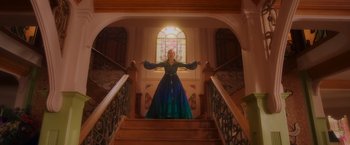 Movie still from “Disenchanted” (2022), directed by Adam Shankman – A woman in a blue dress standing on some stairs; Wide shot, Low angle