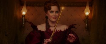 Movie still from “Disenchanted” (2022), directed by Adam Shankman – A woman in a red dress holding a wand in her hand; Close Up shot, Over the shoulder angle