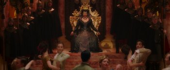 Movie still from “Disenchanted” (2022), directed by Adam Shankman – A woman sitting on top of a throne in a room; Wide shot, High angle