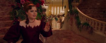 Movie still from “Disenchanted” (2022), directed by Adam Shankman – A woman in a red dress standing in front of a wall; Medium shot, Over the shoulder angle