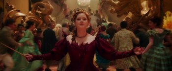 Movie still from “Disenchanted” (2022), directed by Adam Shankman – A woman in a red dress standing in front of a group of people; Medium shot, Low angle