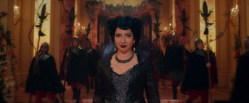 Movie still from “Disenchanted” (2022), directed by Adam Shankman – A woman in a black dress with a black feather collar; Medium shot, Low angle