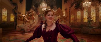 Movie still from “Disenchanted” (2022), directed by Adam Shankman – A woman in a red dress in front of some statues; Medium shot, Low angle