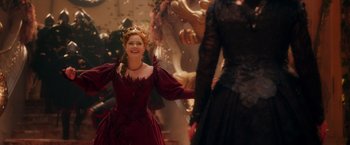 Movie still from “Disenchanted” (2022), directed by Adam Shankman – A woman wearing a red dress and a crown is smiling; Medium shot, Over the shoulder angle