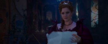 Movie still from “Disenchanted” (2022), directed by Adam Shankman – A woman in a crown holding a piece of paper in her hands; Medium shot, Over the shoulder angle