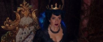 Movie still from “Disenchanted” (2022), directed by Adam Shankman – A woman wearing a black dress and a gold crown; Close Up shot, Over the shoulder angle