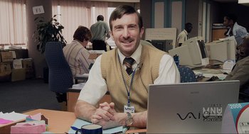 Movie still from “District 9” (2009), directed by Neill Blomkamp – A man sitting in front of a computer at a desk; Medium shot, Over the shoulder angle