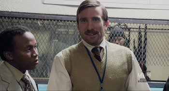 Movie still from “District 9” (2009), directed by Neill Blomkamp – A man in a vest and tie standing in front of a fence; Close Up shot, Over the shoulder angle