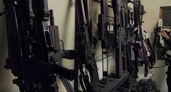 Movie still from “District 9” (2009), directed by Neill Blomkamp – A room filled with lots of guns on the wall; Close Up shot, High angle
