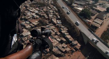 Movie still from “District 9” (2009), directed by Neill Blomkamp – An aerial view of a city with cars driving down the road; Extreme Wide shot, Overhead angle