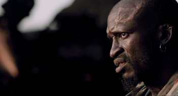 Movie still from “District 9” (2009), directed by Neill Blomkamp – A man's face with a black background; Close Up shot, Low angle