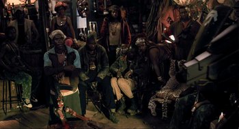 Movie still from “District 9” (2009), directed by Neill Blomkamp – A group of people sitting in a room; Wide shot, High angle