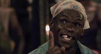 Movie still from “District 9” (2009), directed by Neill Blomkamp – A man with a bandana on his head is making a funny face; Close Up shot, Low angle