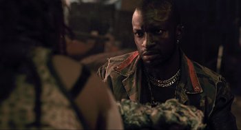 Movie still from “District 9” (2009), directed by Neill Blomkamp – A person wearing a camouflage jacket; Close Up shot, Over the shoulder angle