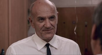 Movie still from “District 9” (2009), directed by Neill Blomkamp – An older man wearing a white shirt and a black tie; Close Up shot, Over the shoulder angle