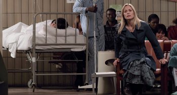 Movie still from “District 9” (2009), directed by Neill Blomkamp – A group of people standing in a room with a baby in a crib in the background; Wide shot, High angle